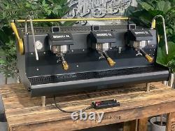 Machine à café espresso personnalisée Synesso Sabre 3 groupes noir et or pour café commercial